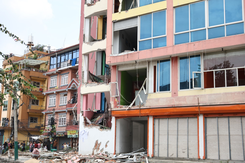 धोबीखोलास्थित साततले घरको बाहिरी भागमा क्षति पुर्‍याएर फर्कियो डोजर (तस्वीरहरू)