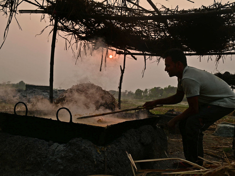 सखर बनाउन उखुको रस उमाल्दै किसान