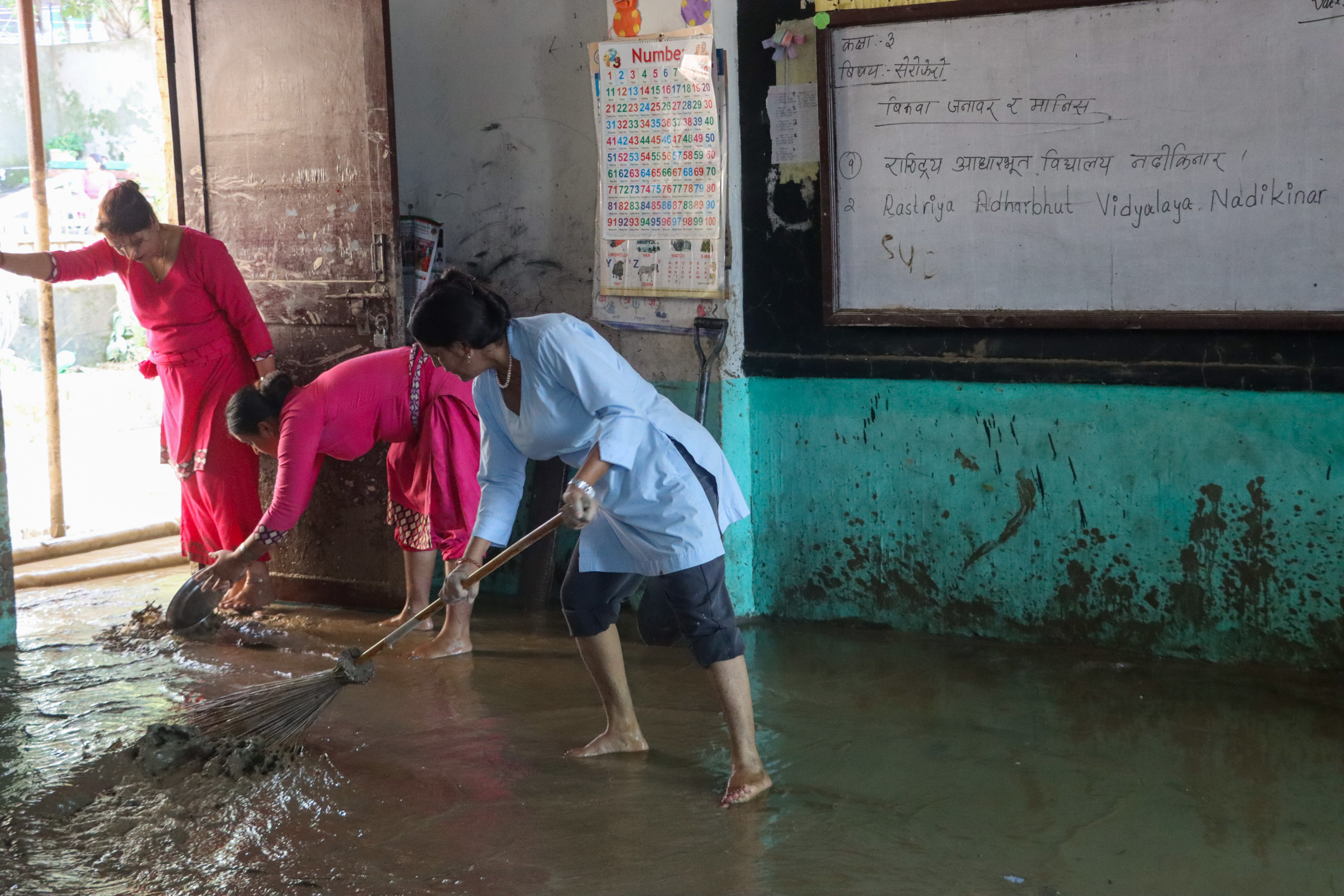सम्बन्धित निकायबाट कोही नआएपछि बाढीले थोपरेको हिलो सोर्न आफैँ कस्सिए शिक्षक–विद्यार्थी (तस्वीरहरू)