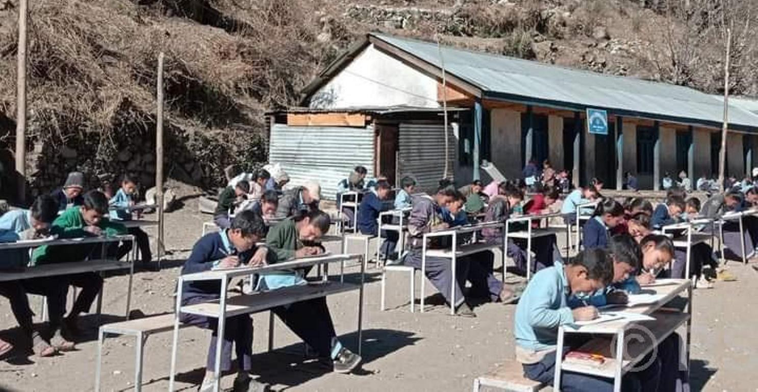 घाममा बसेर परीक्षा दिँदै हुम्लाका विद्यार्थी